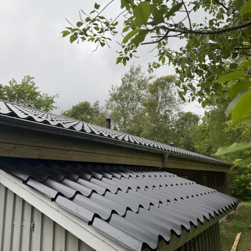 Tagrenovering med nye bølgeplader på udhæng og hovedbygning