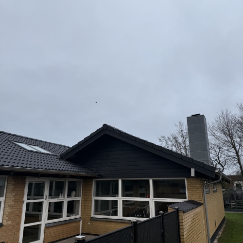 Nyrenoveret tag og facade med nye tagvinduer og sort tagbeklædning.
