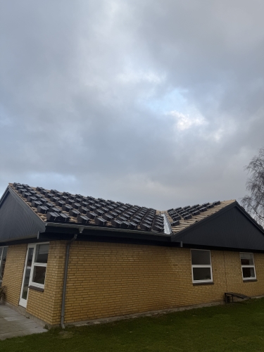 Halvfærdig tagrenovering med tagsten lagt klar til montering – baghave på hus.