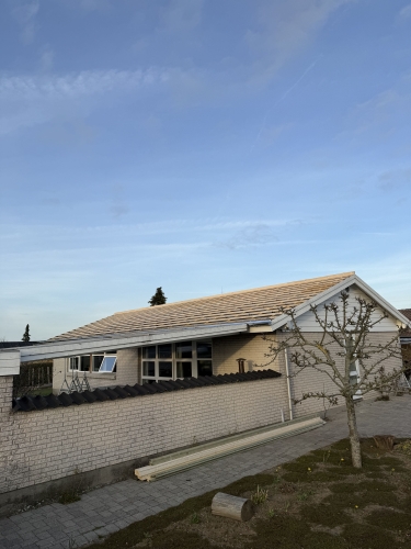  Hus med lys murstensfacade og tagkonstruktion klar til lægning af tagsten.