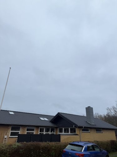Færdig tagrenovering på villa med mørkt tag og opdateret tagkonstruktion.